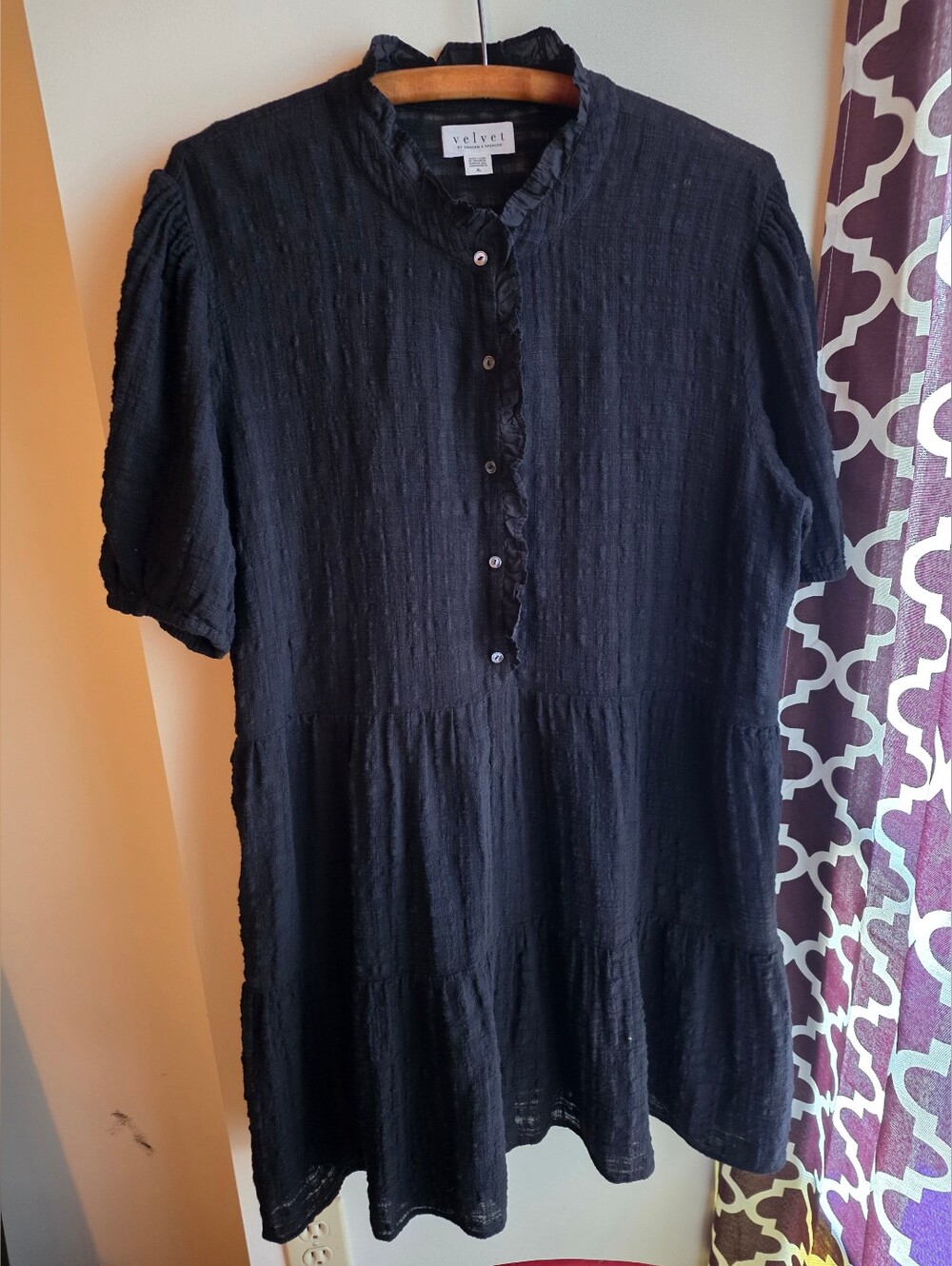 Black tiered mini dress features a ruffled high neck and short sleeves. XL